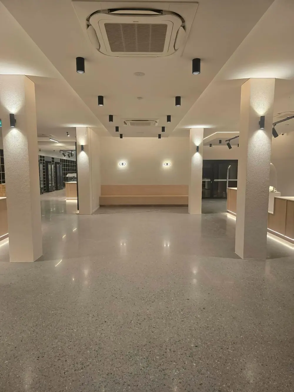 Finished commercial interior with polished concrete floor and illuminated service areas