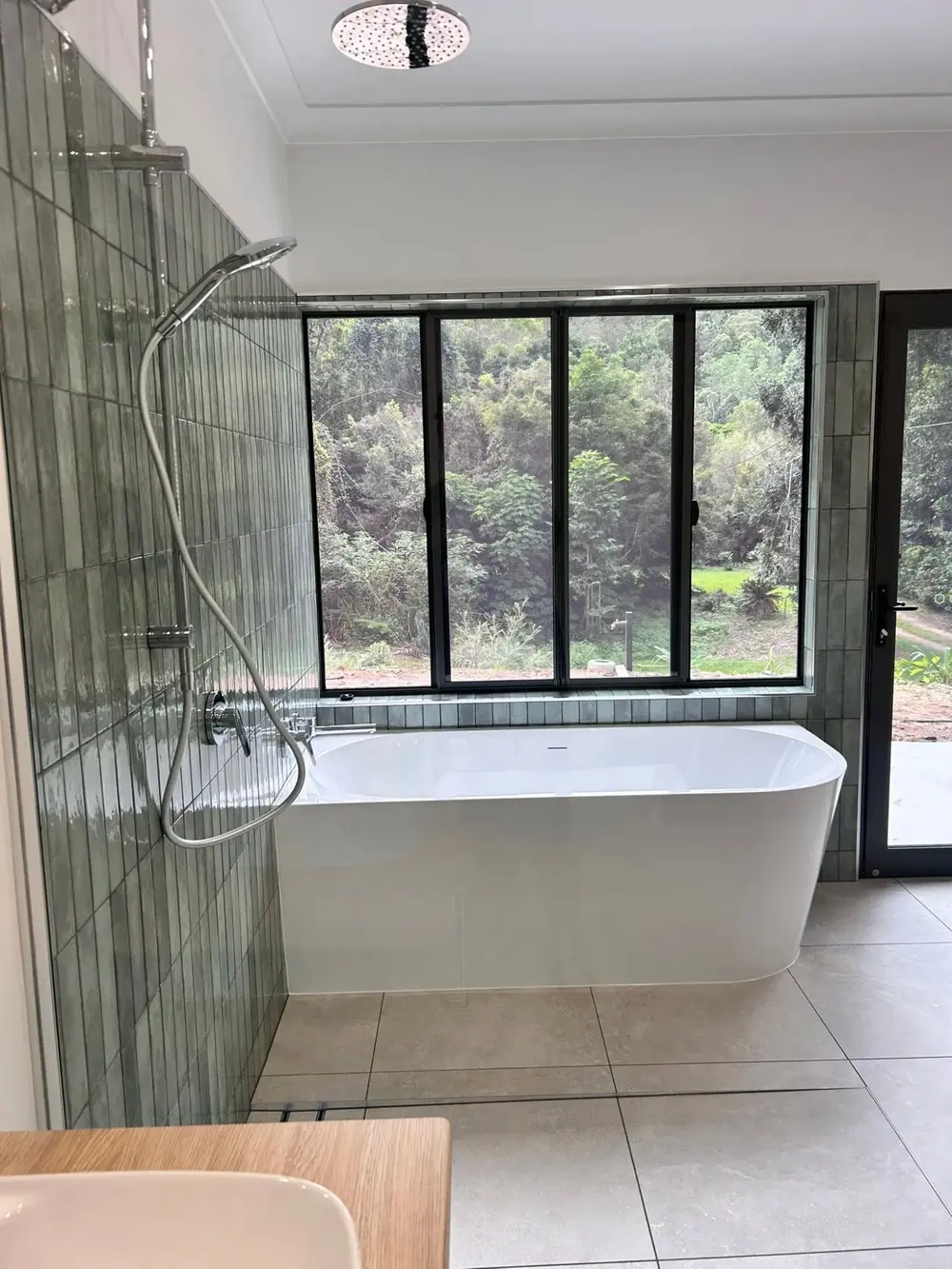 Finished bathroom with freestanding bath, tiled shower and large window